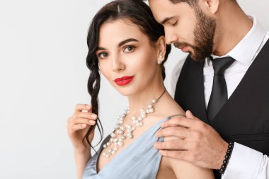 Hafif arka planda şık aksesuarlar giyen genç bir çift.