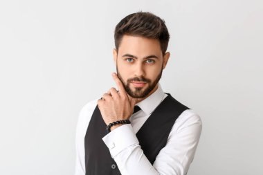 Açık arkaplanda resmi giyinmiş genç bir adam.