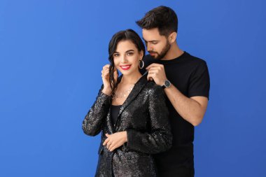 Renkli arka planda şık aksesuarlar giyen genç çift