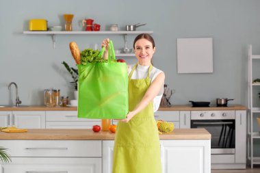 Çantasında yiyecek olan genç bir kadın.