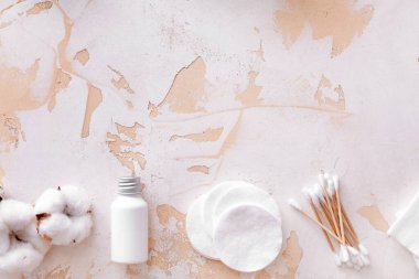 Beyaz arka planda kozmetik ve malzeme içeren pamuk çiçekleri