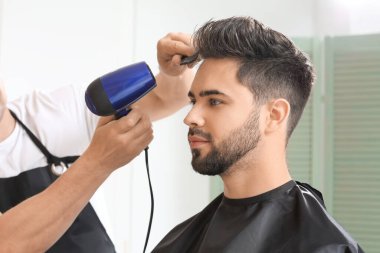 Kuaför müşteriyle kuaförde çalışıyor.