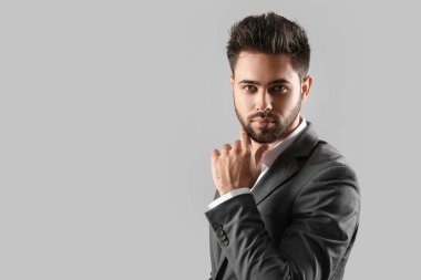 Gri arka planda şık saç stili olan yakışıklı adam.