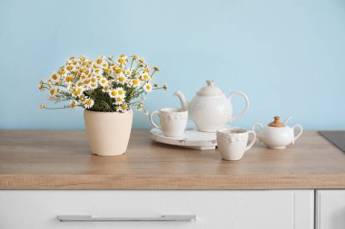 Mutfaktaki masada güzel papatya çiçekleri olan vazo.