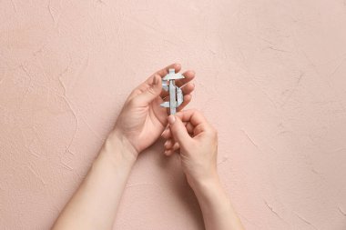 Origami figürüne sahip kadın elleri para banknotlarından yapılmış renk arkaplanı üzerinde