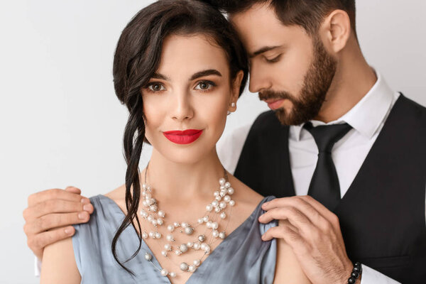 Young couple wearing stylish accessories on light background