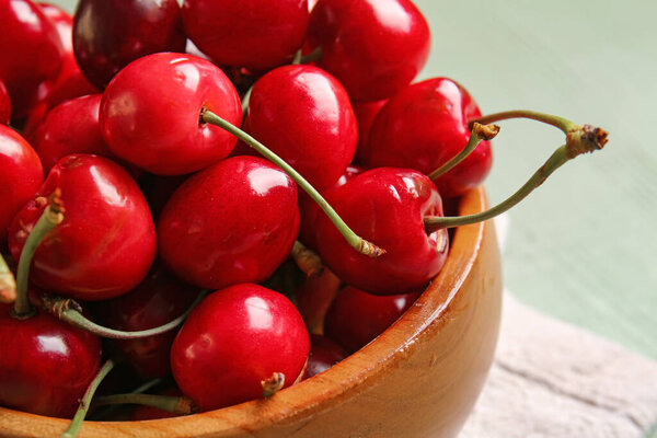 Bowl with sweet cherry on table, closeup