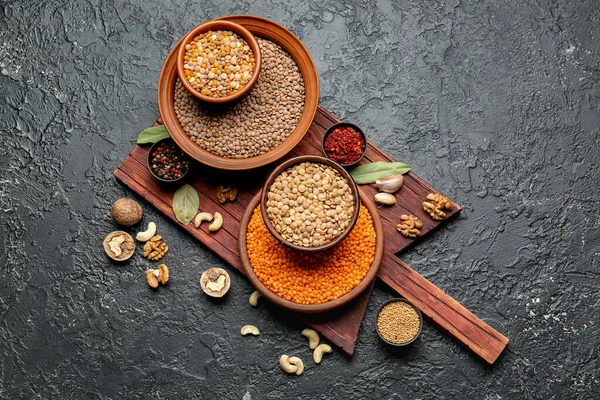 Verschiedene Rohe Linsen Mit Gewürzen Auf Dunklem Hintergrund — Stockfoto