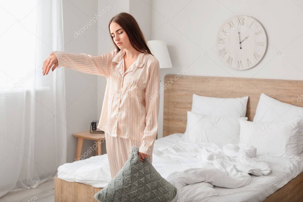 Young female sleepwalker in bedroom