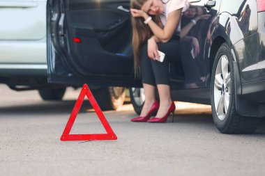 Yolda kaza yaptıktan sonra kırık arabaların yanında dur işareti var.
