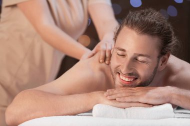 Spa salonunda masaj alan yakışıklı genç adam