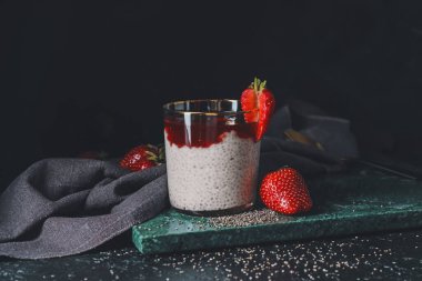 Koyu arkaplanda cam kaplı lezzetli çilekli tatlı.