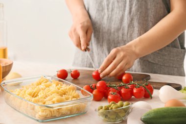 Yemek masasında lezzetli makarna hazırlayan bir kadın.