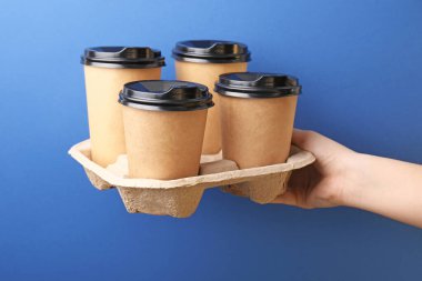 Arka planda kahve fincanları olan bir kadın el.