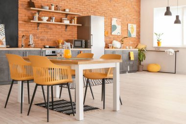 Yemek masası olan modern mutfağın şık iç tasarımı.