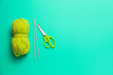 Örgü ipliği ve renk arkaplanındaki iğnelerle makas
