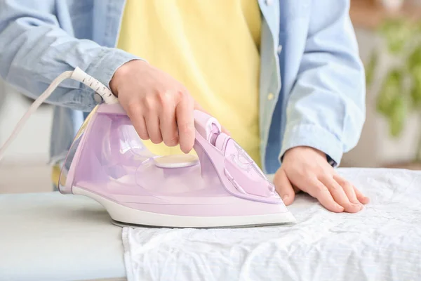 若い女性が家で洗濯物をアイロン掛け クローズアップ — ストック写真