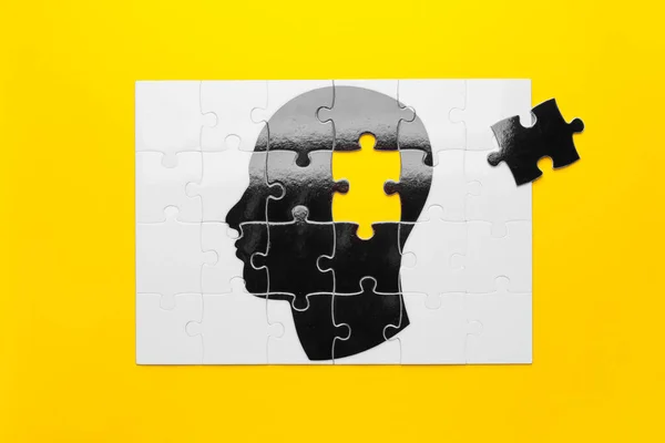 Jigsaw puzzle with human head on color background. Concept of dementia