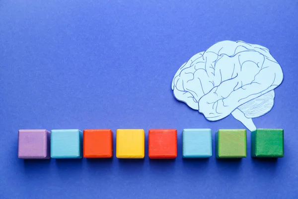 色の背景にキューブと紙の脳 失読症の概念 — ストック写真