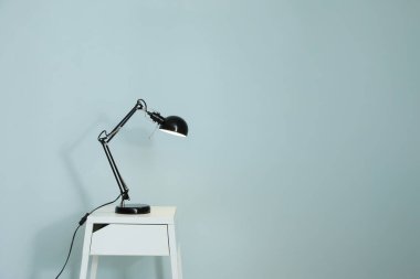 Lamba renkli duvarın yanındaki masada.