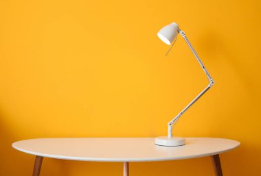 Renkli duvarın yanındaki masada parlayan lamba