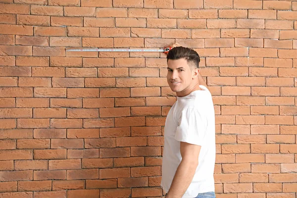 Young Man Measuring Tape Brick Wall — Stock Photo, Image