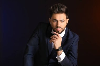 Siyah arka planda şık saç stili olan yakışıklı adam.