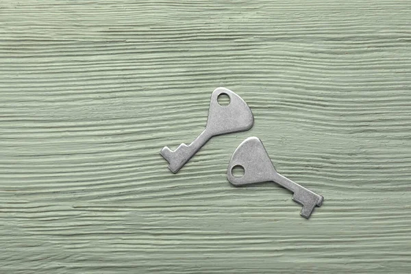 Silver keys on wooden background