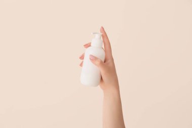 Hafif arka planda krem sürmüş genç bir kadının eli