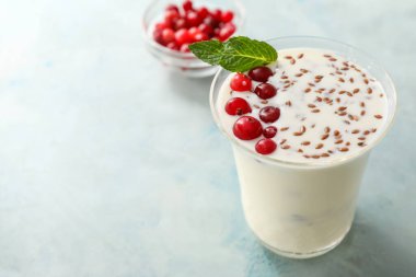 Renkli arkaplanda böğürtlen ve keten tohumlu yoğurt.