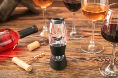 Şişe ve ahşap arka planda gözlüklü şarap havalandırıcısı.