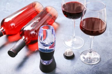 Arka planda şişe ve gözlüklü şarap havalandırıcısı.