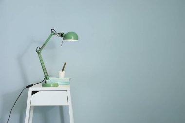 Lamba renkli duvarın yanındaki masada.