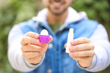 Dudak kremi sürmüş yakışıklı genç adam, yakın plan.