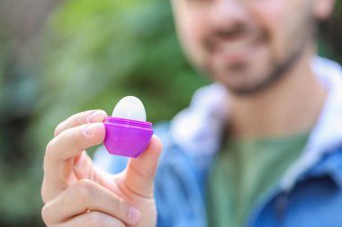 Dudak merhemi sürmüş yakışıklı genç adam, yakın plan.