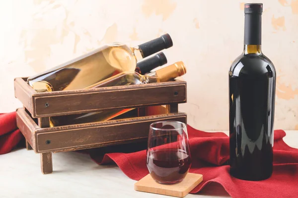 Glass and bottles of wine on white background