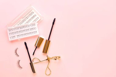 Maskara, kirpik uzantıları ve renk arkaplanında bigudi