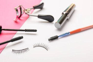 Siyah maskara, takma kirpik ve renk arkaplanda bigudi.