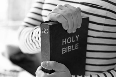 Evinde İncil 'i olan genç adam, yakın plan.