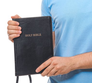 Beyaz arka planda İncil 'i olan genç adam, yakın plan.