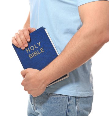 Beyaz arka planda İncil 'i olan genç adam, yakın plan.
