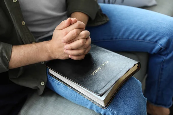 성경을 가지고 집에서 기도하는 젊은이 — 스톡 사진