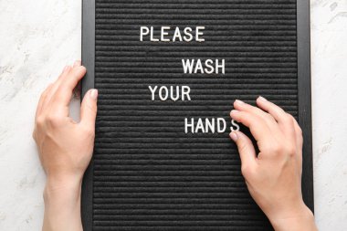 Kadın eli ve yatağı yazı ile lütfen, ellerinizi hafif arka planda yıkayın.