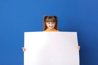 Arkaplanda boş posteri olan küçük bir kız.