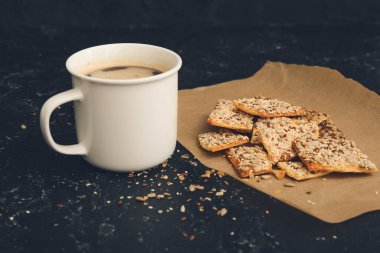 Mısır gevreği kurabiyeleri ve arka planda bir fincan kahve.