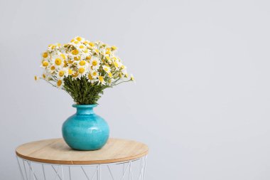 Masanın üzerinde güzel papatya çiçekleri olan bir vazo.