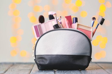 Dekoratif kozmetik ürünleri olan çanta açık arkaplanda