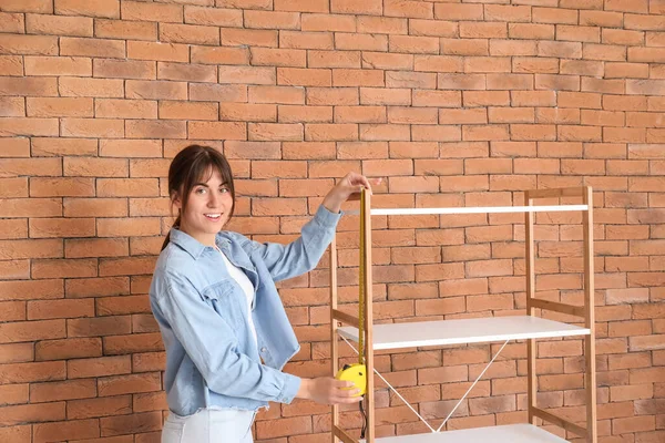 Jovem Mulher Medindo Prateleira Unidade Dentro Casa — Fotografia de Stock