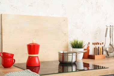 Mutfak tezgahında soba ve mutfak gereçleri.