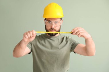 Renk arkaplanında mezura olan erkek işçi